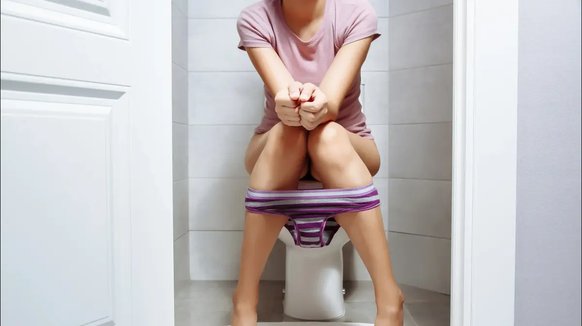 Sitting on toilet peeing