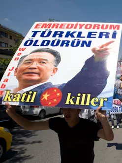 גולים אויגורים מפגינים ונושאים שלט עם תמונת נשיא סין, הו ז'ינטאו, עם הכיתוב "אני פוקד להרוג טורקים", החודש בטורקיה