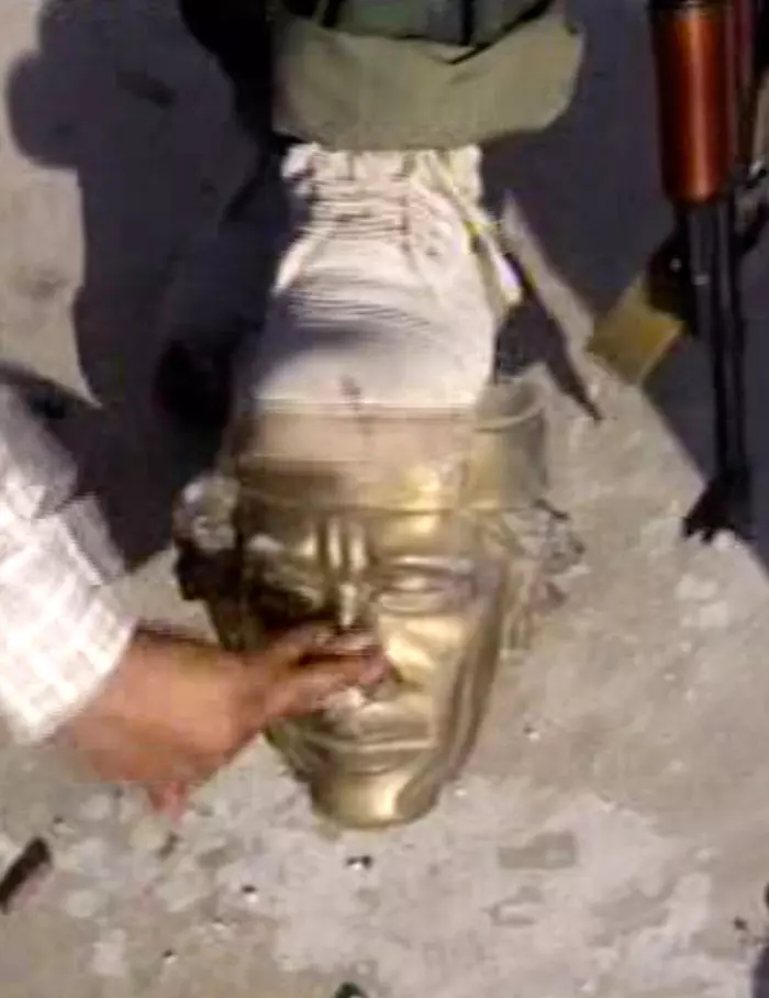 המורדים דורכים על פסלו המוזהב של קדאפי במתחם מגוריו בטריפולי