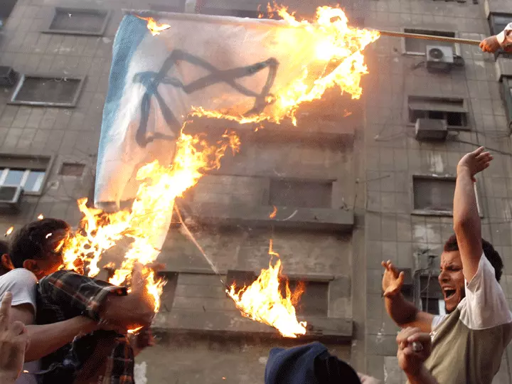 מפגינים שורפים את דגל ישראל מחוץ לשגרירות ביום שישי