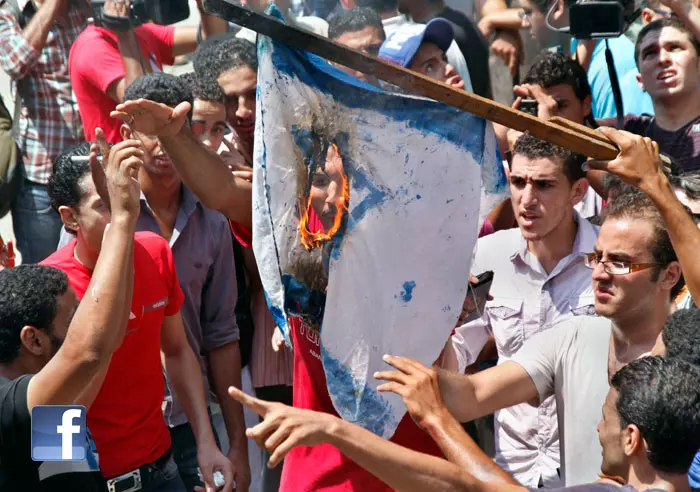 המפגינים שורפים את דגל ישראל שהורד מתורן השגרירות, קהיר לפני כחודש וחצי