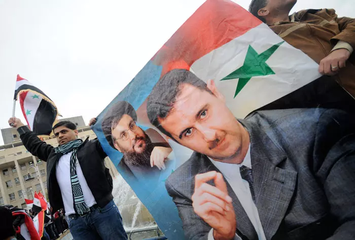 "שאלה של זמן" עד שייפול. מפגינים תומכי אסד נושאים את תמונתו, אתמול בדמשק