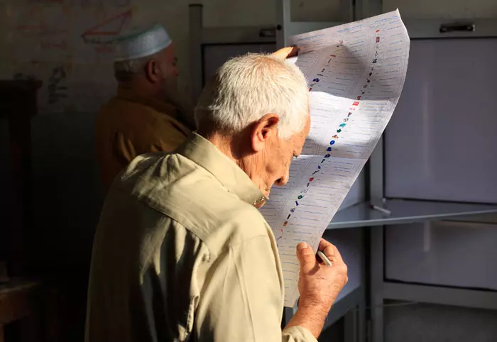 קשיש מתבונן ברשימת המועמדים לבחירות. האחים המוסלמים צפוים לזכות בשליש מהקולות