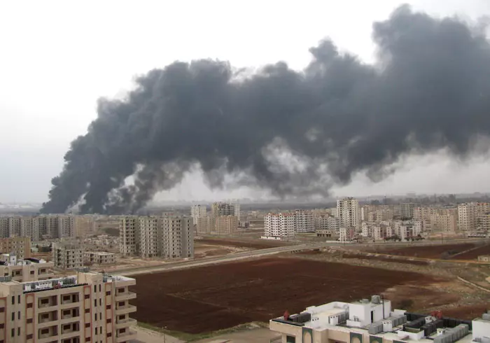 עשן עולה ביום חמישי מעל העיר חומס, שם פוצצו המורדים צינור נפט