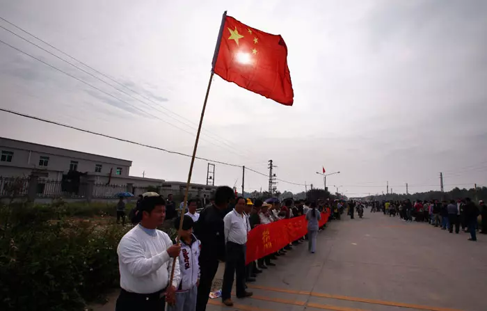 דגל סין מונף בטקס קבלת פנים בה חזרו הרשויות לכפר ווקאן שמרד נגדן במשך שבועיים, דצמבר 2011