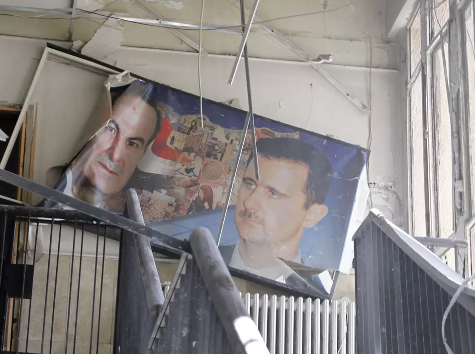 תמונותיהם של בשאר אסד ואביו חאפז במטה הביטחון שנפגע אתמול בפיגוע בדמשק