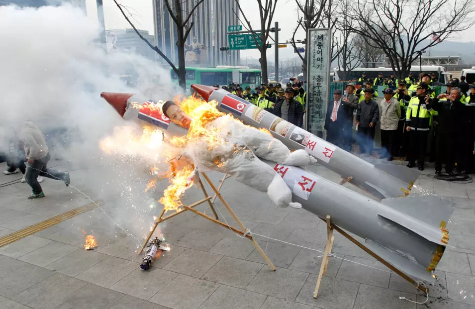 מפגינים בסיאול שורפים דגם של הטיל, ועליו תמונת מנהיג צפון קוריאה