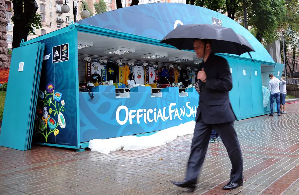 אוקראיני פוסע בגשם בקייב, כשבחנויות המזכרות עדיין לא מצליחים כל כך למכור