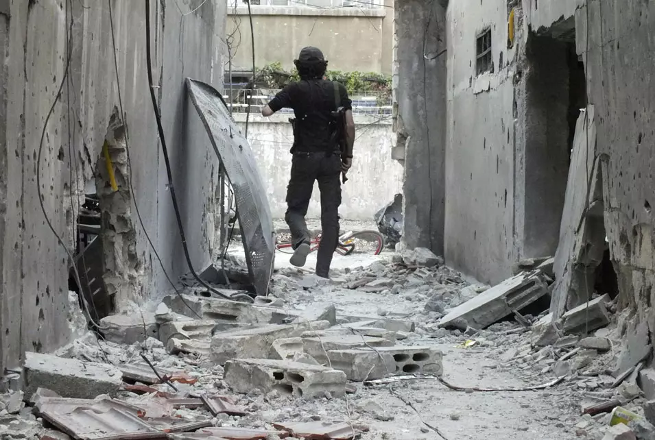 לוחם של מחתרת "הצבא הסורי החופשי" בין ההריסות מההפגזות ברובע אל-קוסור בעיר חומס