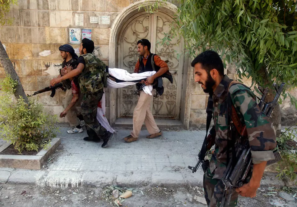 לוחמים בצבא הסורי החופשי נושאים את גופת חברם ברחובות חלב