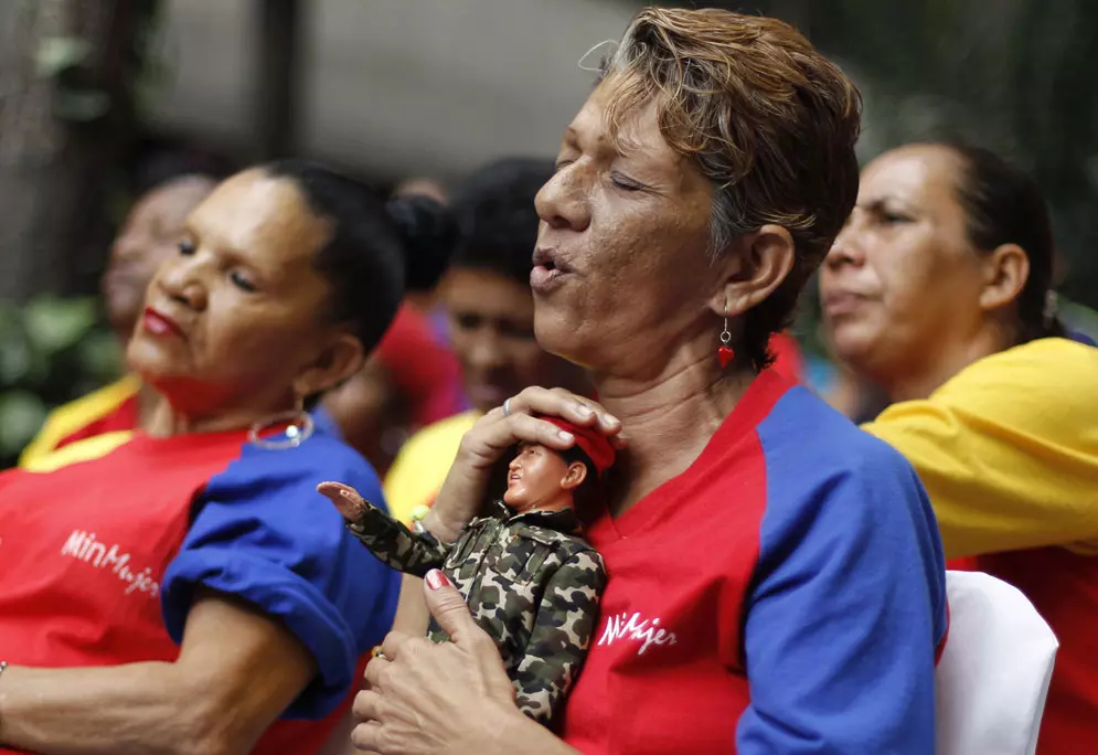 נשים מודאגות נושאות בובה בדמותו נשיא ונצואלה הוגו צ'אווס בבירה קראקס. 12 בדצמבר 2012
