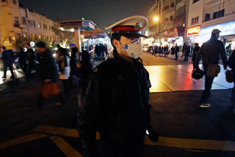איש ביטחון מתגונן מזיהום האוויר בטהרן