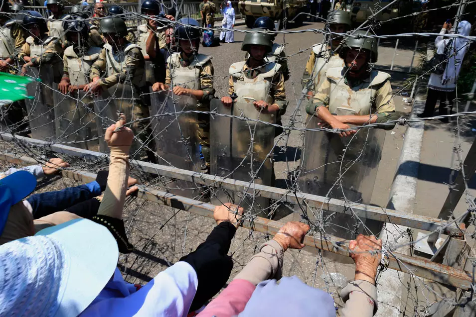 מפגינים מנסים לשבור מחסום שהציבו חיילי הצבא, אמש בקהיר
