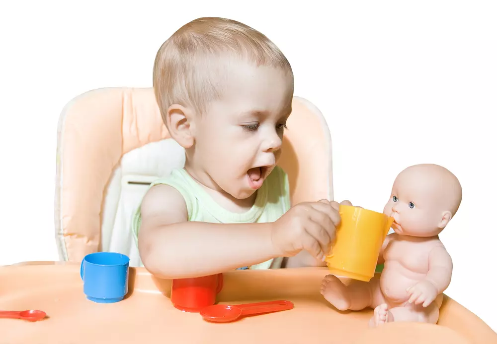 תינוק מאכיל בובה. משחקי דמיון עם בובות ודמויות הם חשובים מאוד
