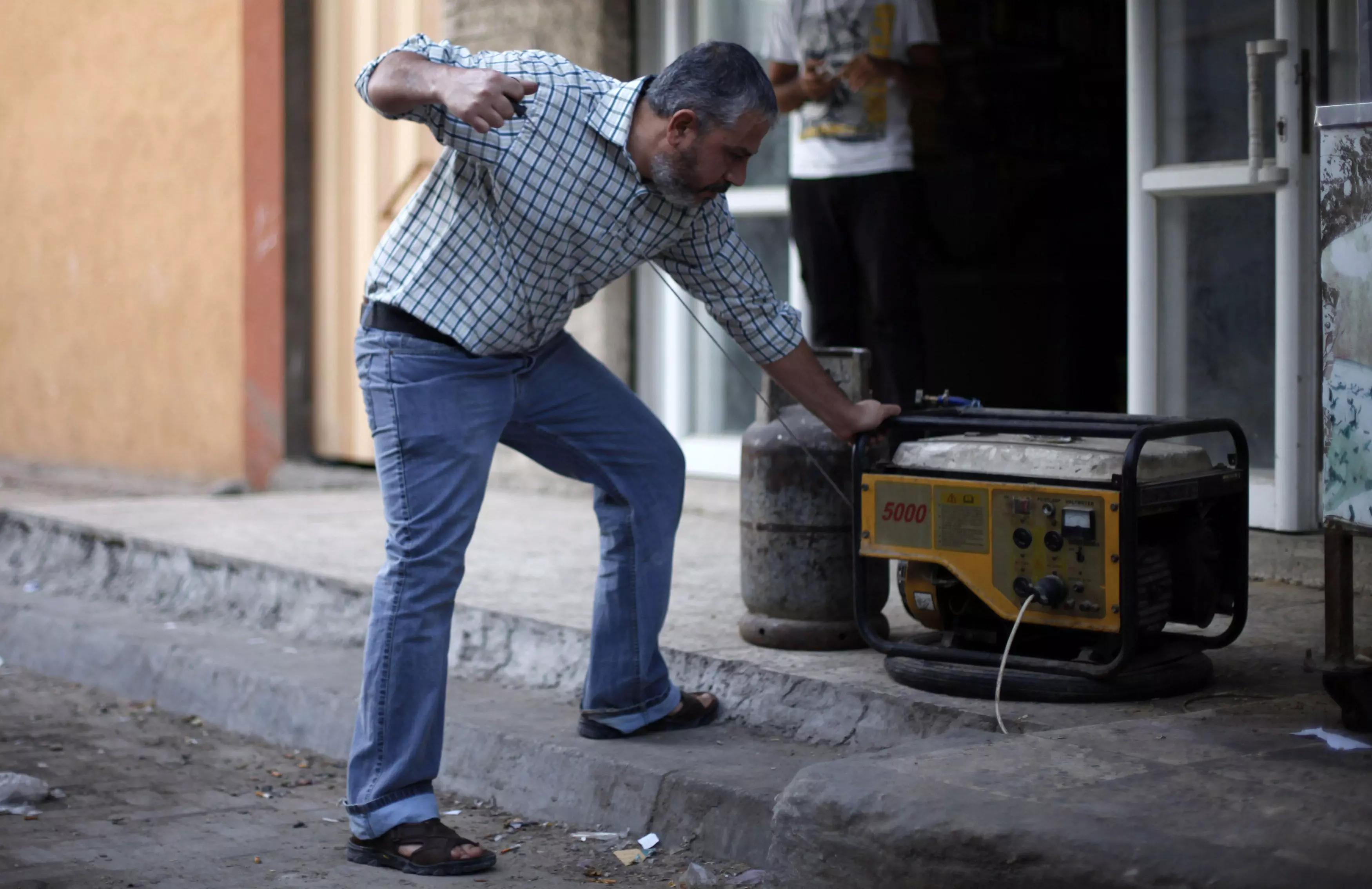 פלסטיני מפעיל גנרטור בעזה, השבוע