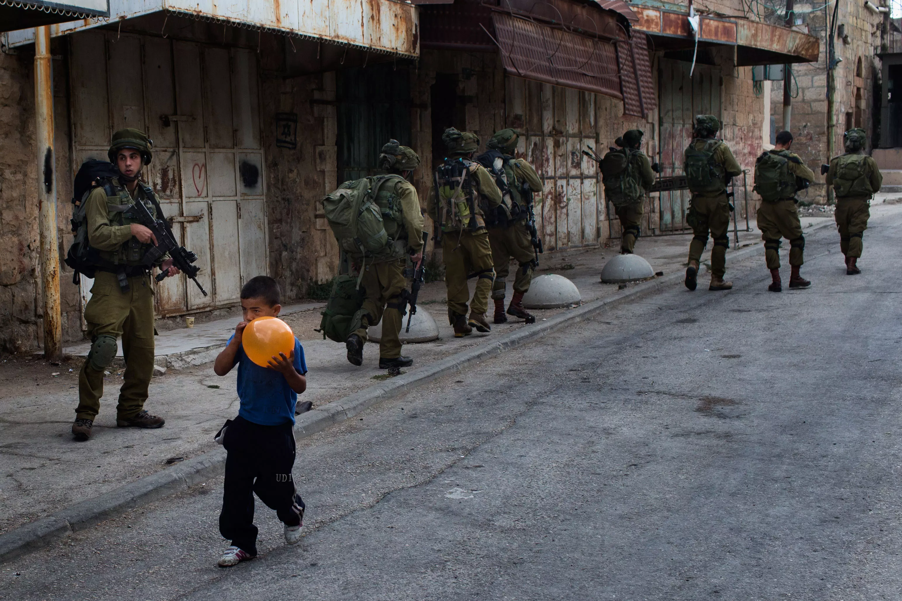 אלפי בתים נטושים, רחובות ריקים מפלסטינים. חיילים וילד פלסטיני בחברון