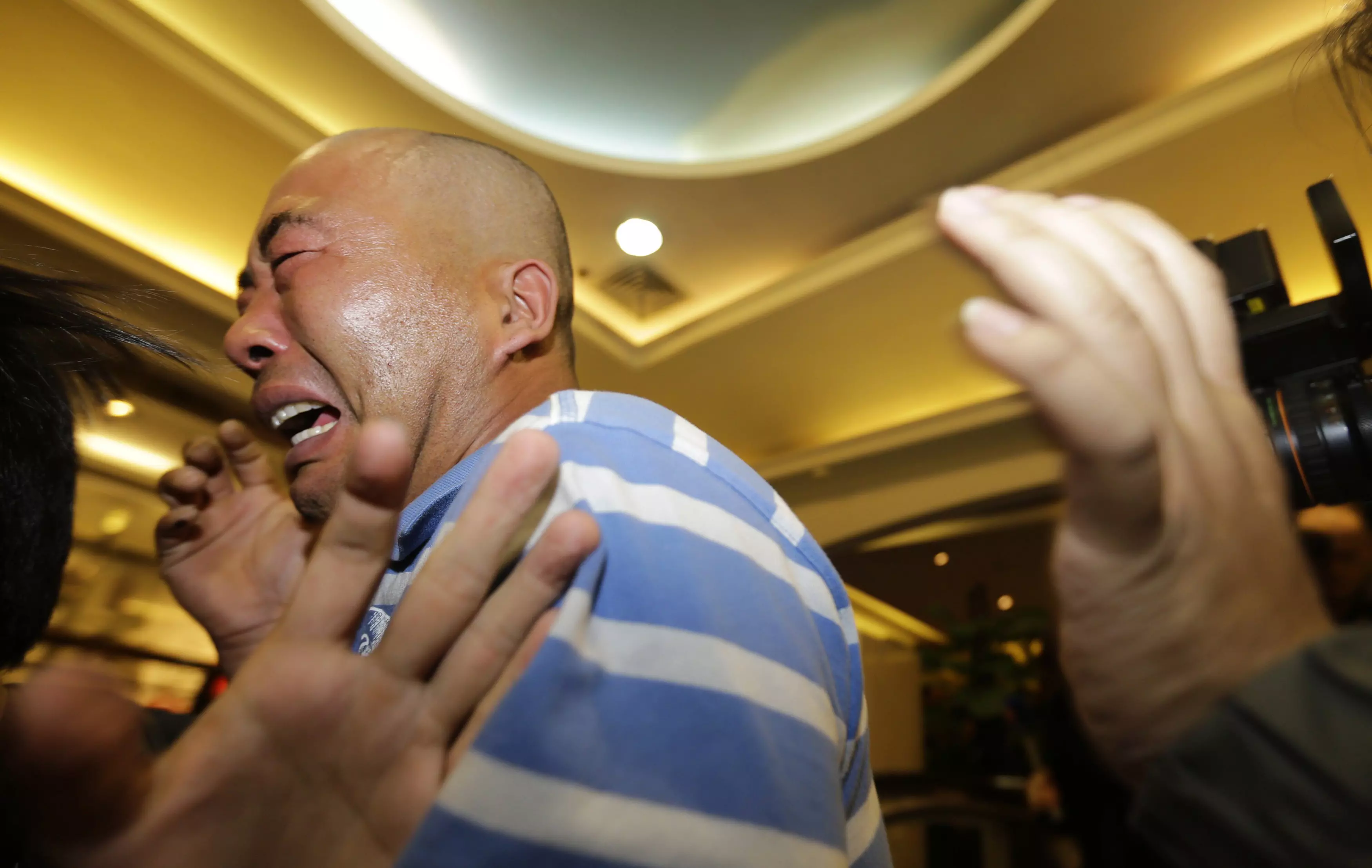 אדם שקרוב משפחתו היה על הטיסה, מגיב בבכי להודעת ממשלת מלזיה