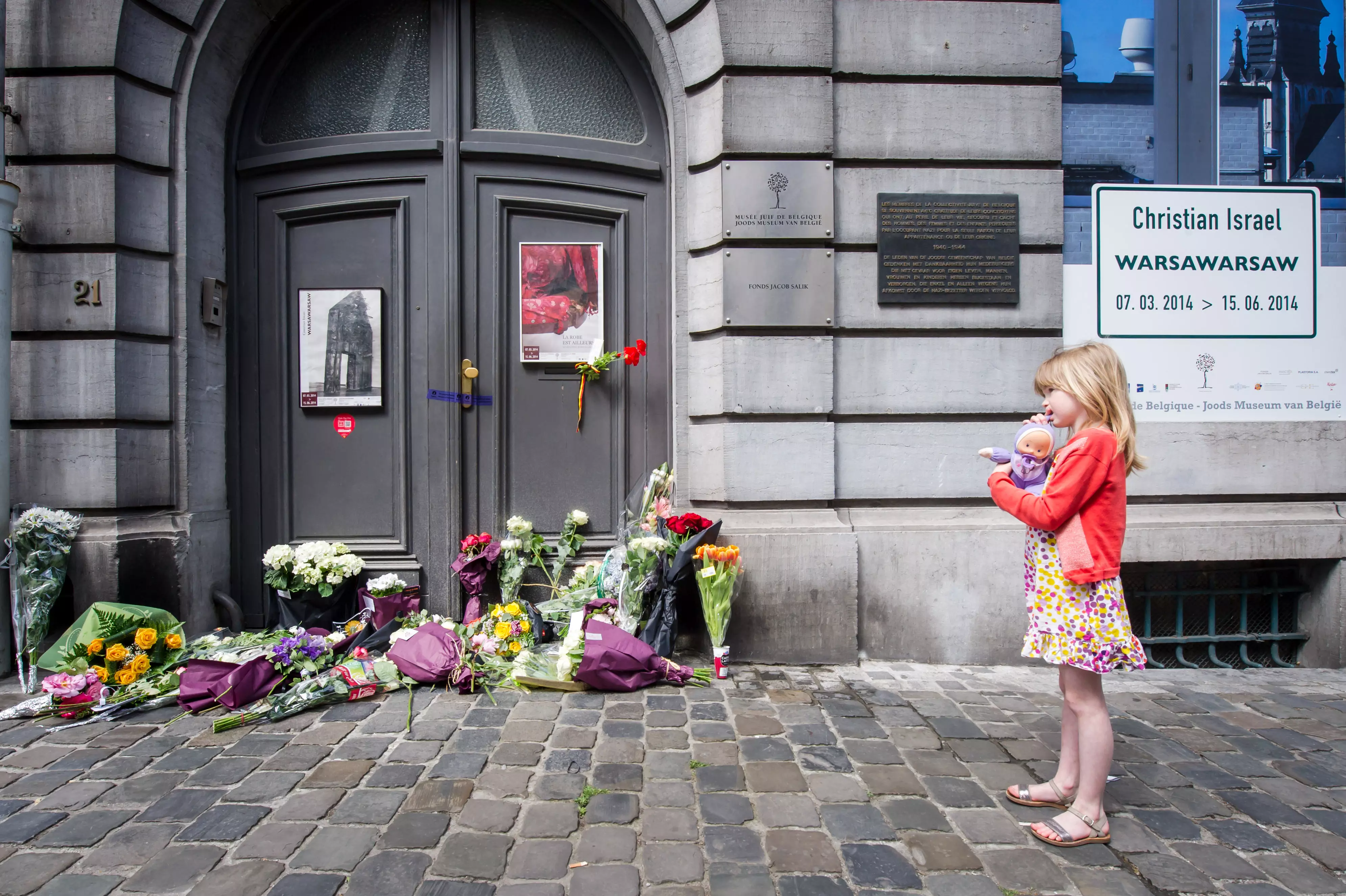 ילדה עומדת מחוץ למוזיאון בו אירע הפיגוע