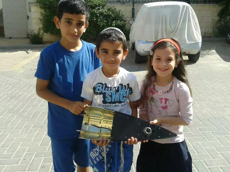 ילדים מנתיבות מצטלמים למזכרת עם חלק מטיל מיירט של "כיפת ברזל", אתמול