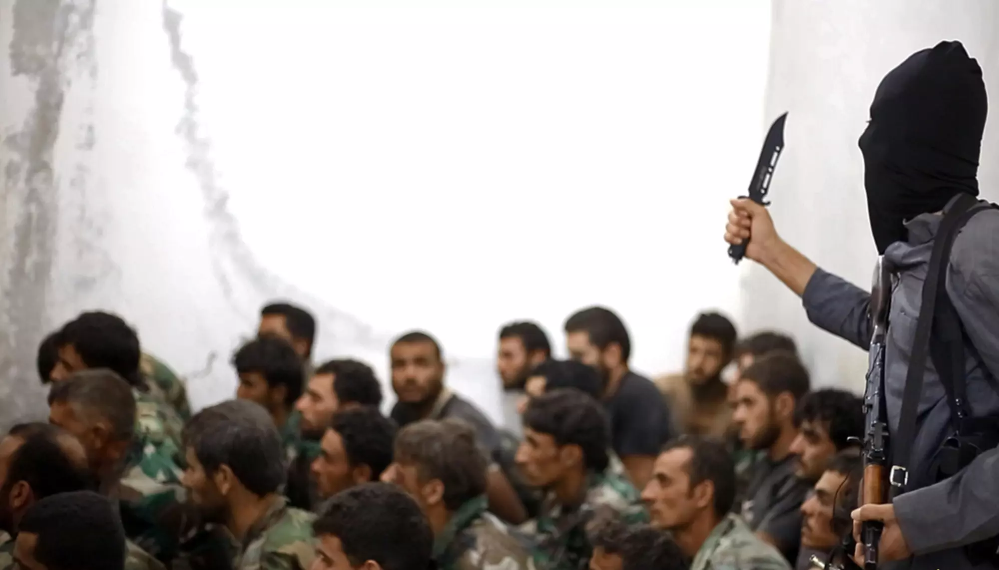 לוחם דאעש שומר על קבוצת חיילים שבויים בבסיס