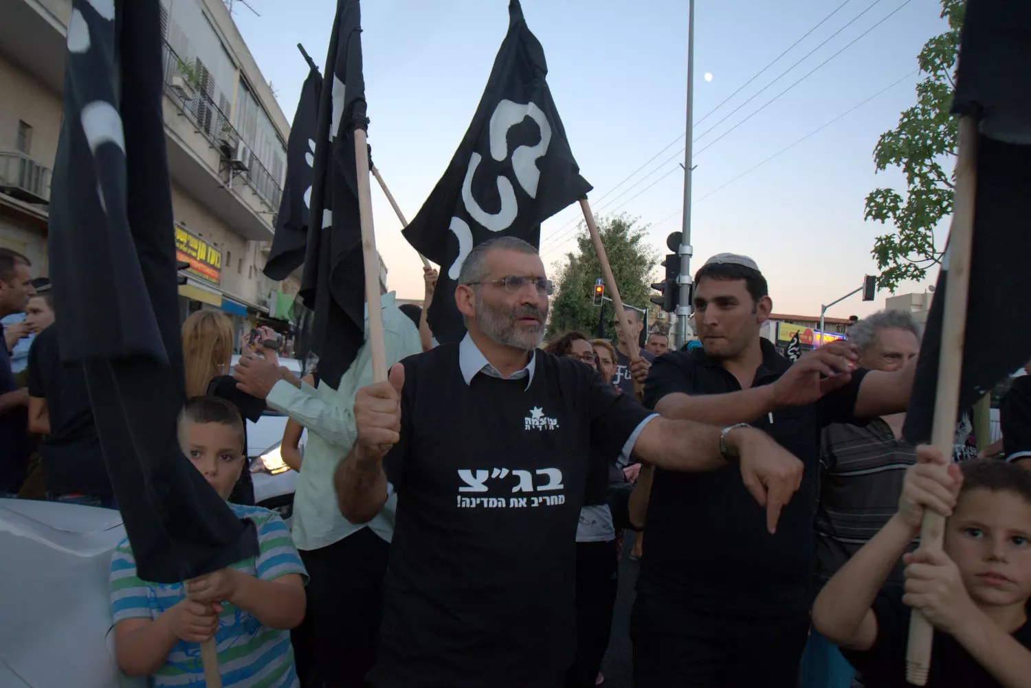 בן ארי בהפגנה עם הדגלים המזכירים את אלו של דאעש