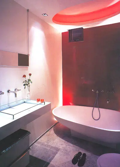 קיר אדום-יין בחר האמבטיה. בתקרה עוצבה נישה אובלית שמפיצה אור אדמדם