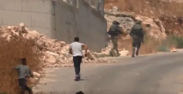 צילום מסך מתוך סרטון של חיילים בורחים מפלסטינים שמשליכים אבנים בתקוע שביו"ש, 22 יוני 2019