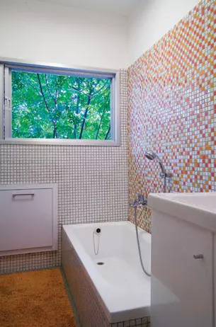 בחדר האמבטיה שני קירות פסיפס, האחד בגוון אפור אחיד ובשני שילובים של כתום ואדום