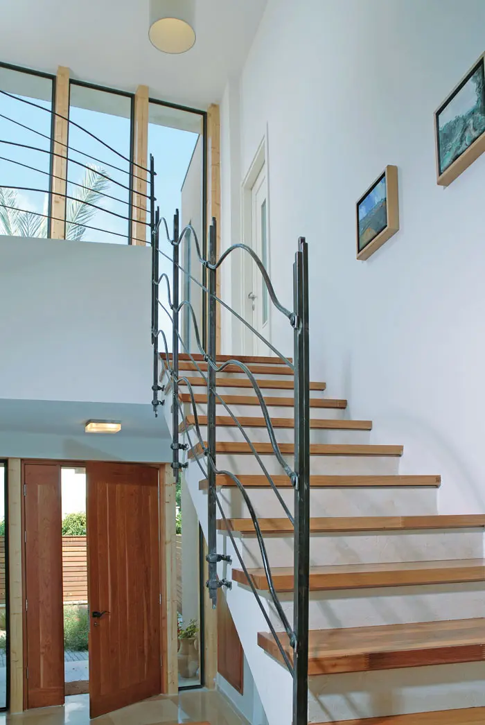 מעלה המדרגות לקומה העליונה, הנמצא מול הירידה לחדר המשפחה, משלים את המבנה הספירלי של חלל הבית