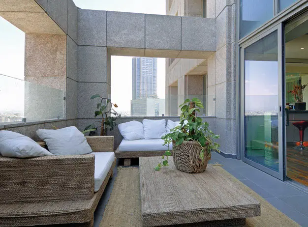 המרפסת שמקושטת בצמחיה מטפסת ממוקמת מול הכניסה לדירה, ומאפשרת מבט אל החוץ כבר מפתח הדירה