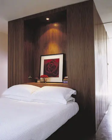 גב המיטה בחדר השינה של ההורים הוא חלק מקוביית העץ הפונה אל חדר העבודה הקטן ומכילה בתוכה שירותים ומקלחת