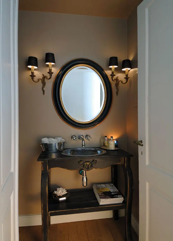 בשרותי האורחים, שולחן עתיק הוסב למשטח אמבטיה, מראה אליפטית משלימה את המראה הנוסטלגיה