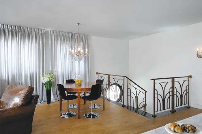 מעקה המדרגות שתוכנן על ידי סובוטקה מהווה רקע דקורטיבי לפינת האוכל הקטנה