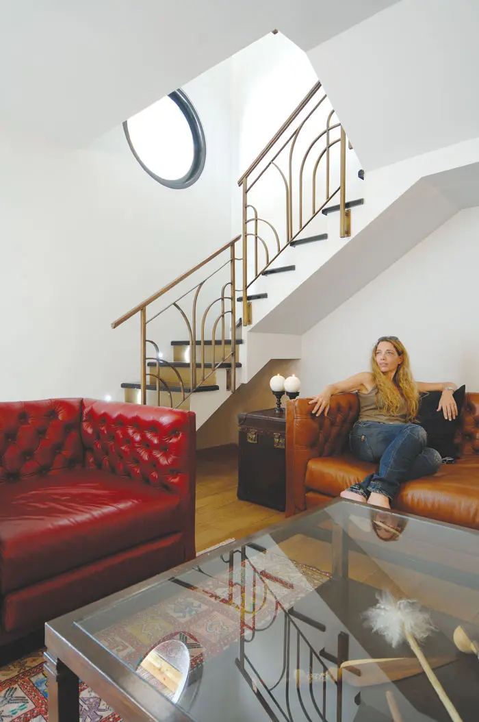 בקומה התחתונה, פינת משפחה, ברקע בולט גרם המדרגות, שכל אחת מהן בנויה משלח צבוע לק שחור והרום עשוי לוח פליז