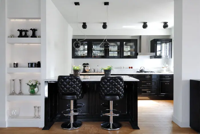 מטבח פתוח לסלון צבוע שחור לק, משלים את מראה סלון. בארונות העליונים נקבעה מראה המוסיפה עומק לארונות ולמראה כללי של המטבח