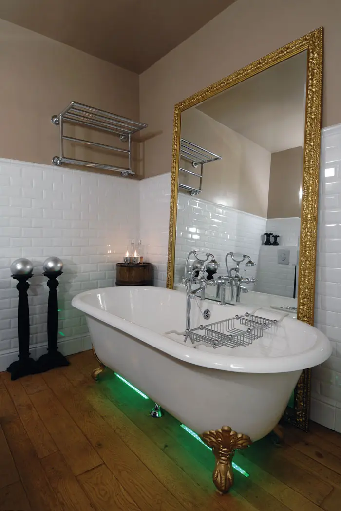 יופיה של האמבטיה הודגש על ידי פס אור המשנה גווניו ומראה גדולה ניצבת על הרצפה אלמנט שחוזר על עצמו בעיצוב הכללי של הבית