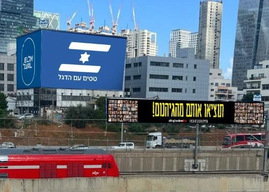 שילוט חוצות של אל על לצד שילוט של מטה משפחות החטופים במימון החברה.