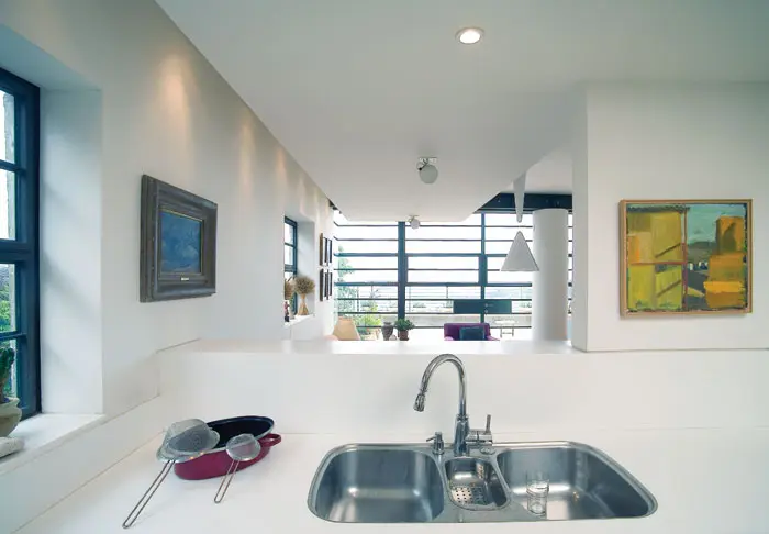 מבט מהמטבח - קיר המטבח חצוי בגובה פונה לנוף ומאפשר קשר עם היושבים בסלון
