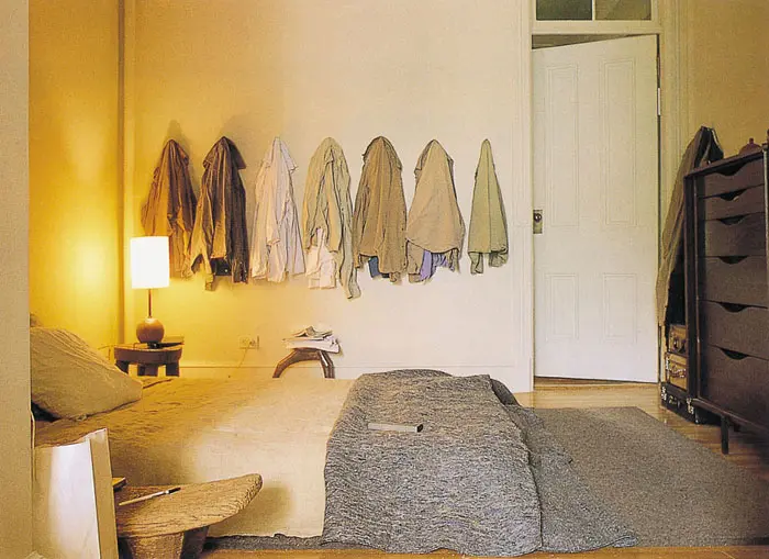 חדר שינה מרוהט בצמצום. החולצות התלויות מהוות מוקד עיצובי