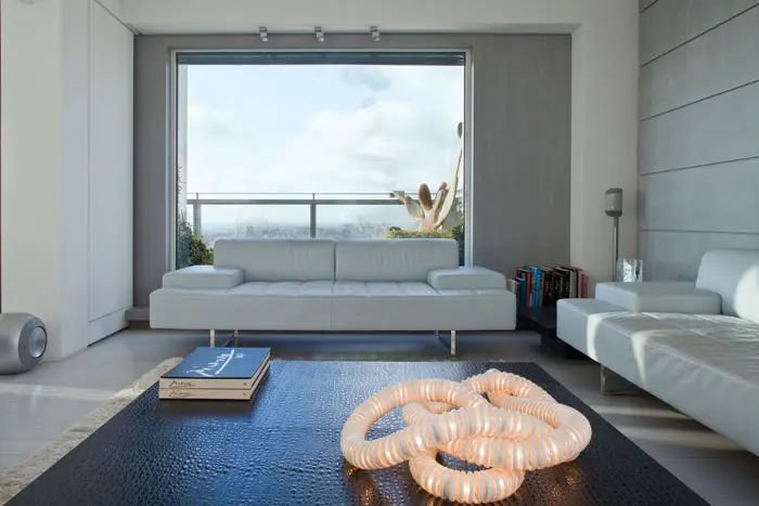 בכניסה לסלון, בצד הימני,פינת הסבה שבמרכזה שולחן קפה גדול מרופד בעור עם מרקם קרוקודיל