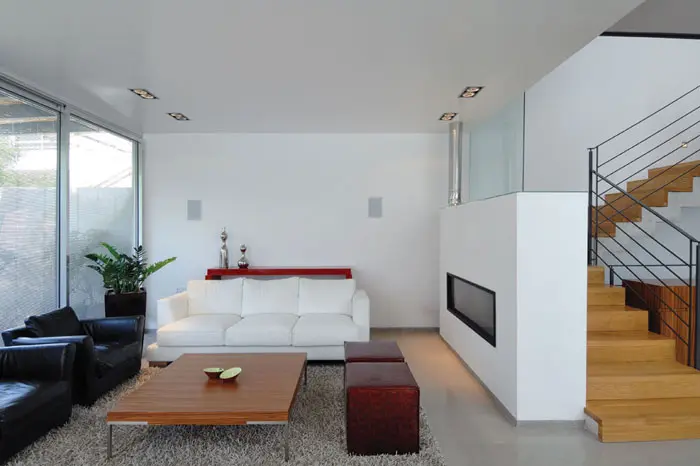 סלון שממנו ניתן להשקיף לגינה שמקיפה מחצית מהבית ולעבר מדרגות המובילו תלקומה העליונה