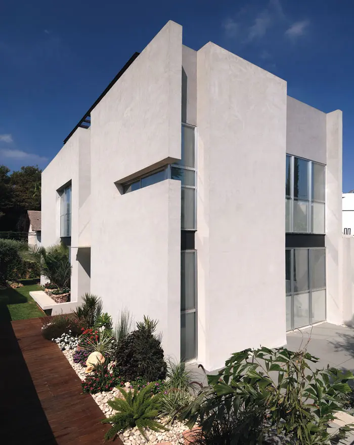 מראה כללי של הבית מבחוץ. משחק של קווים ישרים, בטון וזכוכית