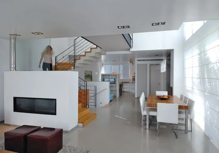 מבט מהסלון לעבר המטבח בקומת הכניסה. לתקרות החללים גבהים שונים