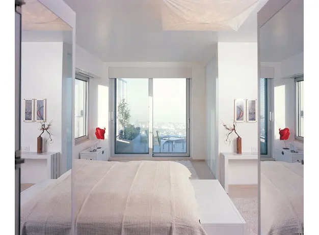 חדר השינה. הצבע השולט הוא לבן שמופיע כמעט בכל חומר - קירות, שטיחים או ריפוד. הצילום צולם מחדר העבודה