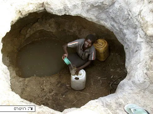 אישה מזימבבואה ממלאת מים מבאר, לאחר שהממשלה סגרה את הסכר ליד עיר הבירה ארארה והאזור התייבש