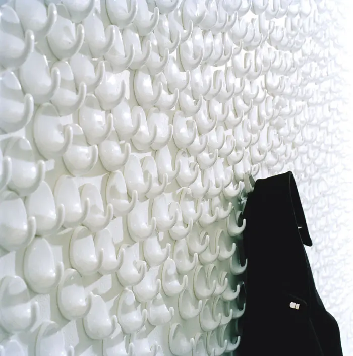 Tensta Konsthall. גלרית אמנות בשטוקהולם, בה קיר המלתחה צופה בטפט שימושי, המורכב מאלפי מתלי פלסטיק פשוטים וצפופים