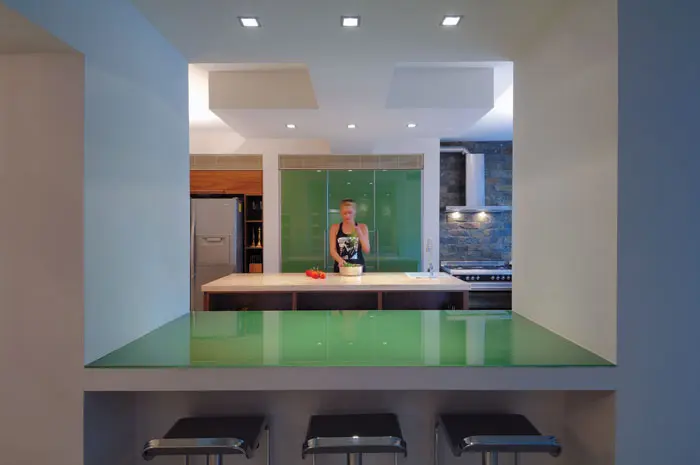 אי אכילה מרווח ומחופה זכוכית ירוקה מהווה דלפק פרקטי ומחבר בין המטבח לסלון