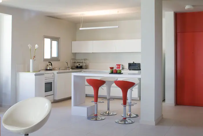 פינת האוכל מפריד בין המטבח לסלון, 2 כיסאות אדומים מתחברים לצבעה של דלת הכניסה