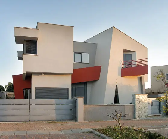 חזית הבית, מציגה תפיסה דה קונסטרוקטיביסטית. קיר אדום משמאל, "פורץ" לתוך המבנה ויוצר צורה חדשה