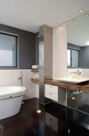 חדר האמבטיה ביחידת ההורים, מרוצף פרקט רץ. קיר פונקציונלי חופה באבני פסיפס